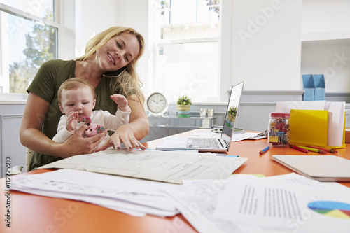 Busy Mother With Baby Running Business From Home photo