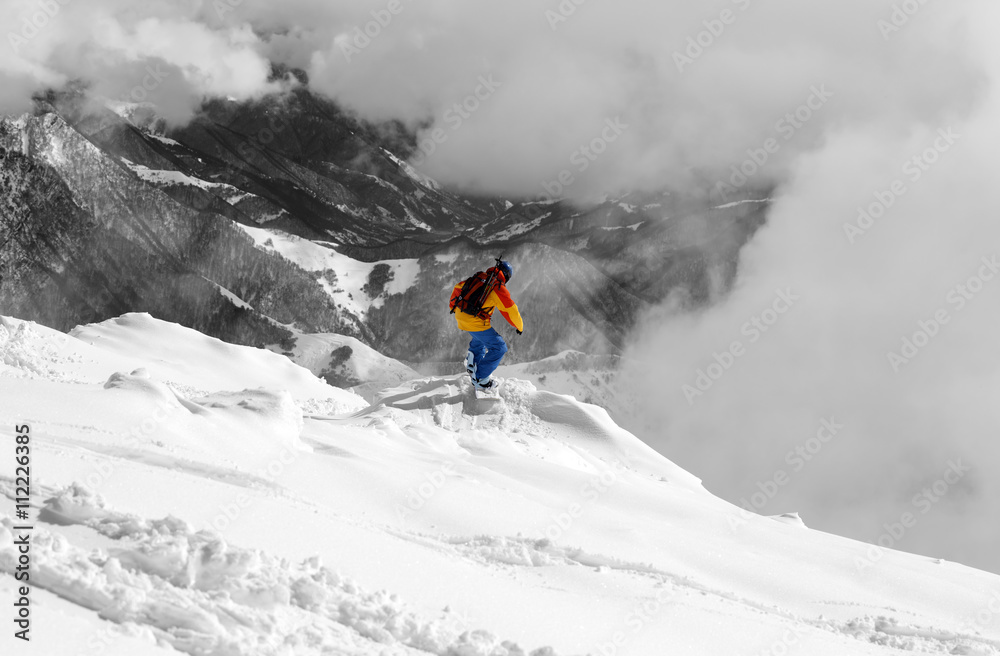 Snowboarder on off-piste slope an mountains in fog. Selective co