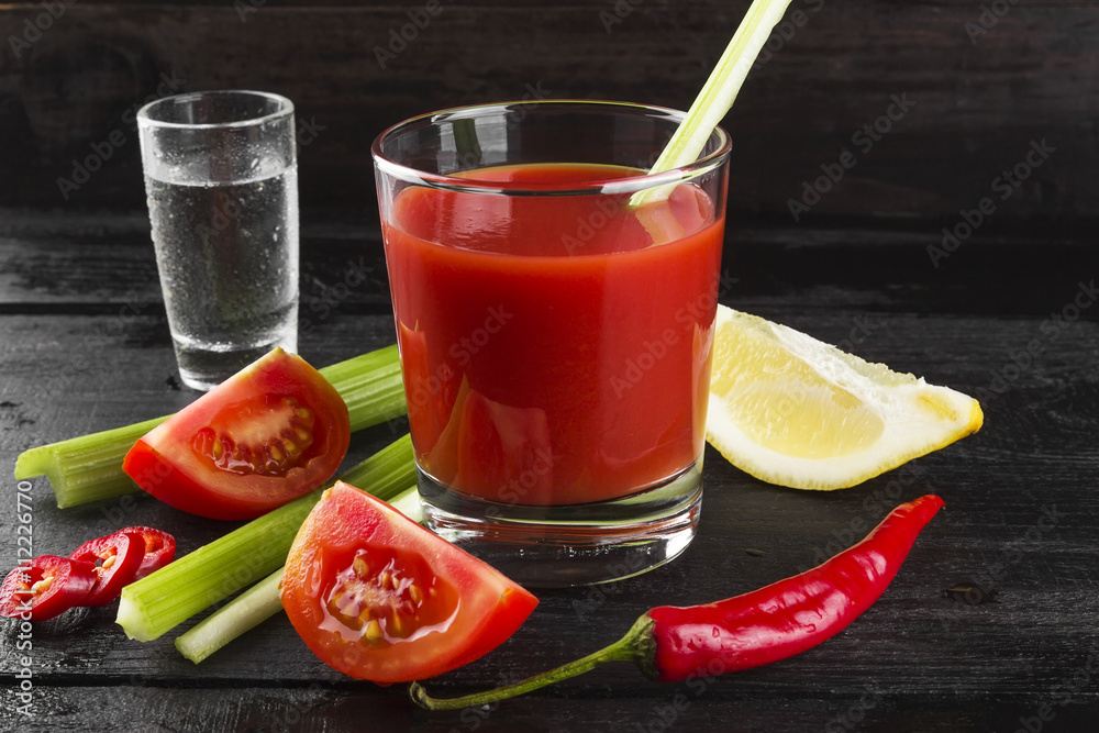 Bloody Mary with celery, lemon, hot pepper on a dark background Bloody Mary with celery, lemon, hot pepper on a dark background