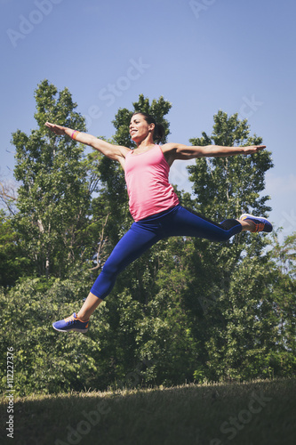 Woman doing jumping exercises in nature