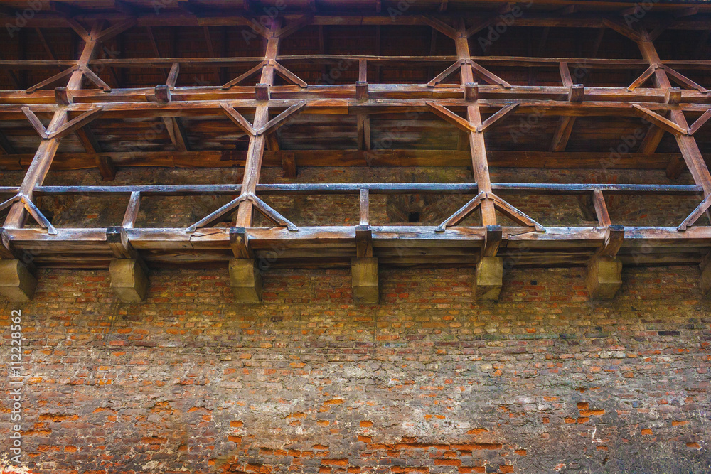 brick wall of an ancient fortress with wooden staircases and pas brick wall of an ancient fortress with wooden staircases and pas