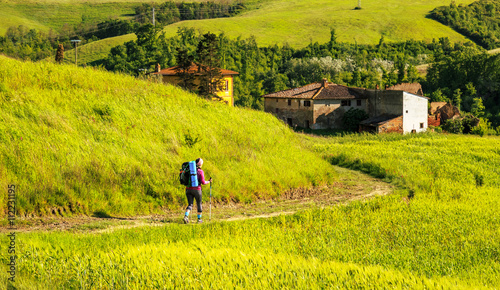 female hiker walking across tuscany hills © Feel good studio