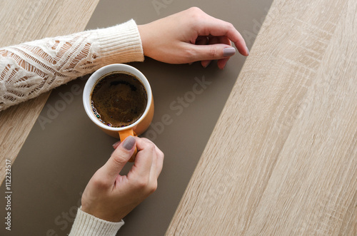 Hands on desk with cup of coffee