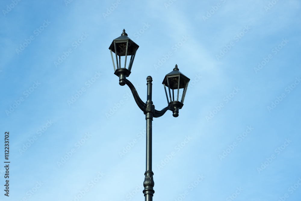 Black lamp post on a background of blue sky 
