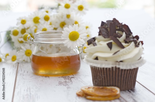 Muffin. Cupcake with chocolate and honey and daisy flower.