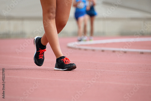 Girls on race walking on athletic track