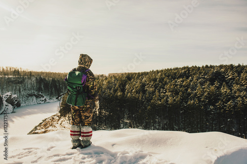 Caucasian hiker standing on snowy hilltop photo