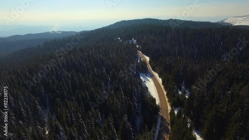 Aerial view of the forest in winter .Flight over the snowy fit trees.Flying over the winter forest.Aerial view of the road in the woods photo