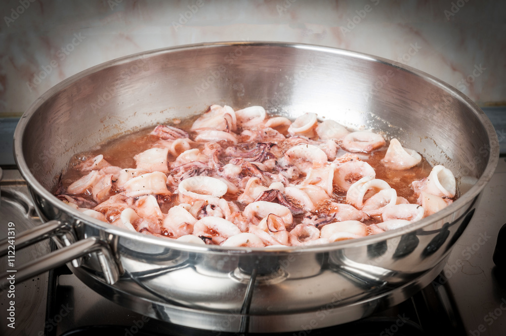 Stewed squid rings in tomato sauce in pan