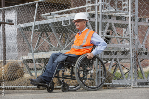 Caucasian engineer in wheelchair on construction site photo