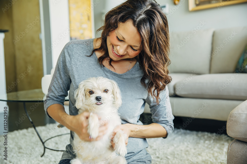 Caucasian woman petting dog in living room Caucasian woman petting dog in living room