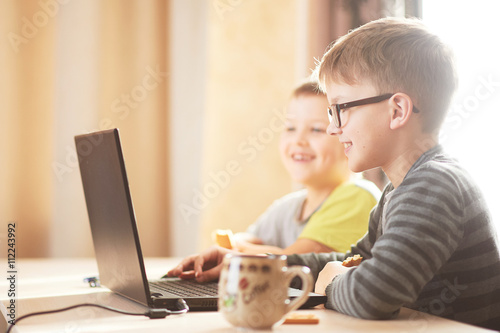 Happy boy sitting With laptop computer