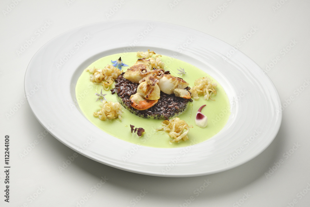 Appetizer braised scallops and black rice on pea cream Appetizer braised scallops and black rice on pea cream