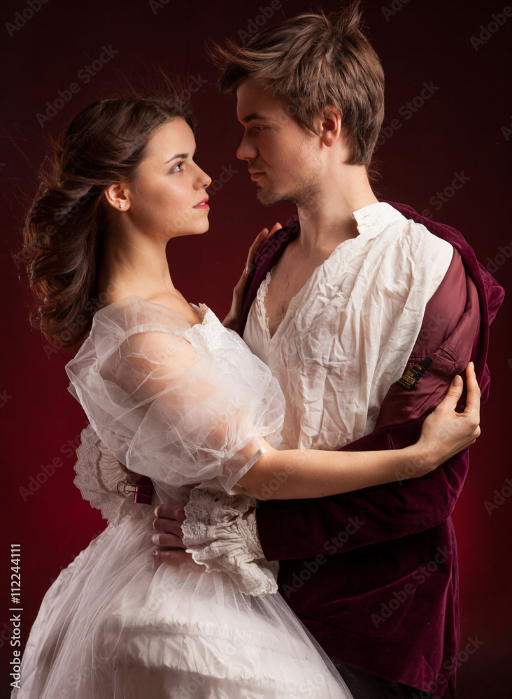 Beautiful man and woman dressed in medieval clothing stand in a room of ...