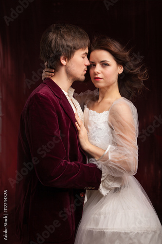 pretty young lady in old time and man in red medieval dress 