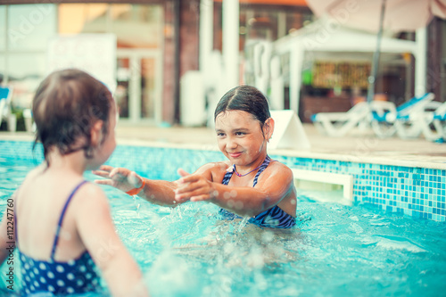 Little happy girl in swimming pool. Kid splashing on pool © hazyar
