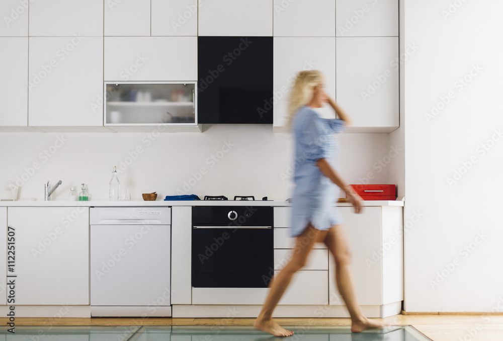 Woman walking in modern kitchen Woman walking in modern kitchen