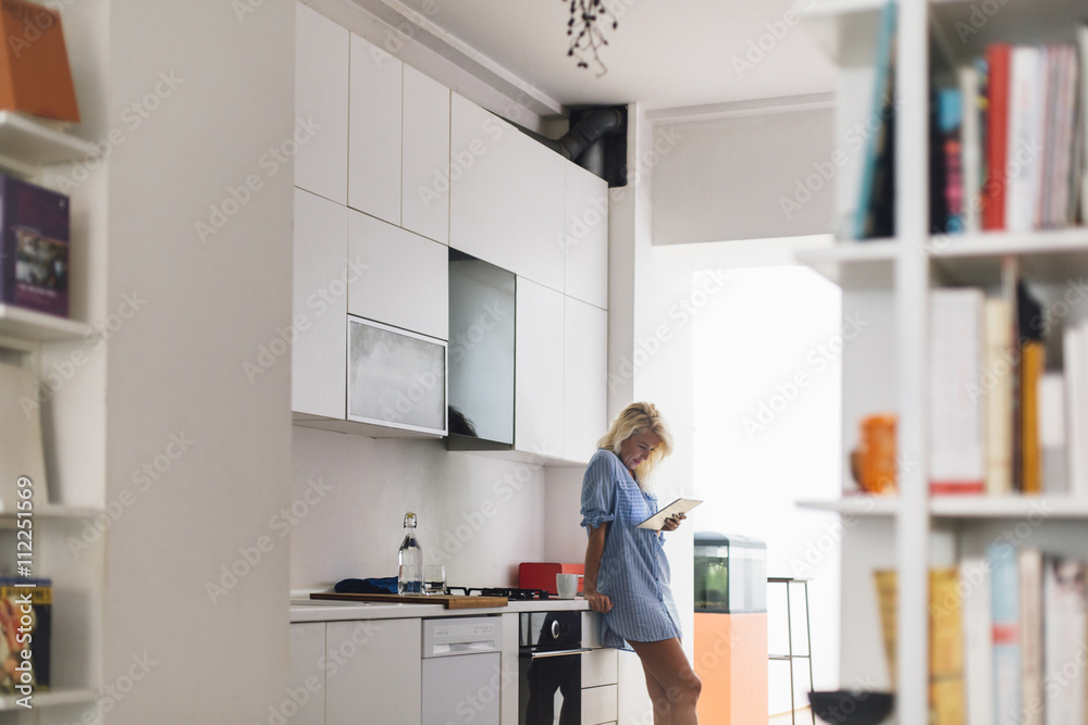 Woman using digital tablet in kitchen Woman using digital tablet in kitchen