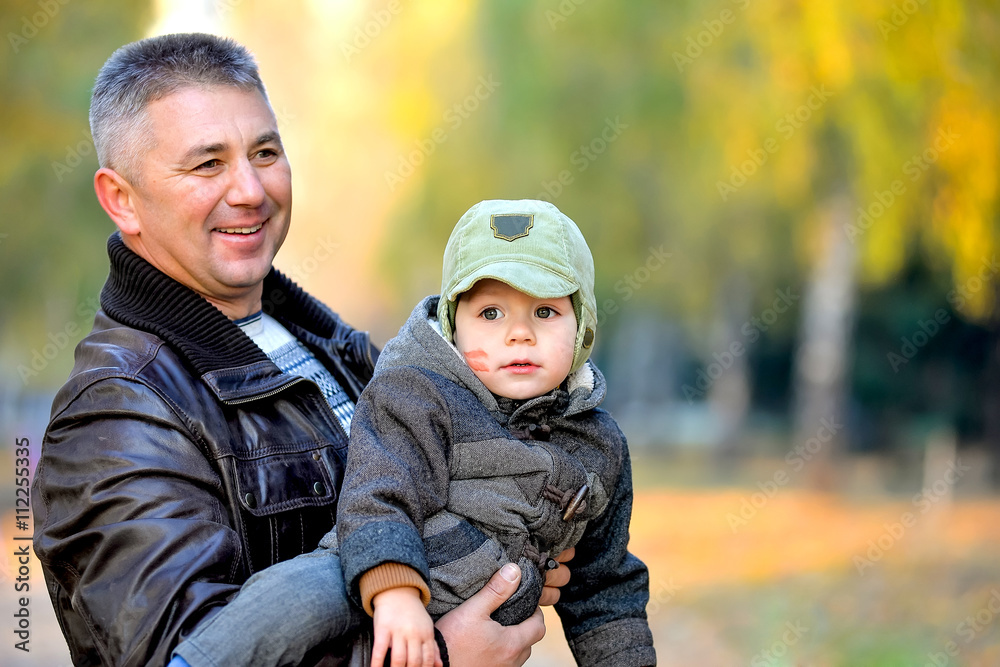 Father playing with his son in the park in autumn. Father playing with his son in the park in autumn.