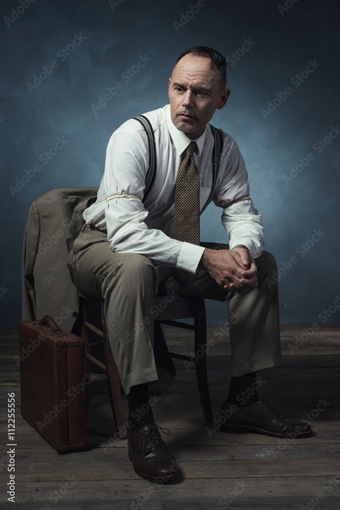 Retro 1940 businessman sitting on chair in room. Retro 1940 businessman sitting on chair in room.