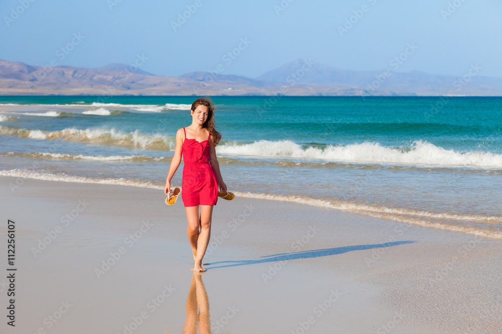 Attractive young woman walking on the beach