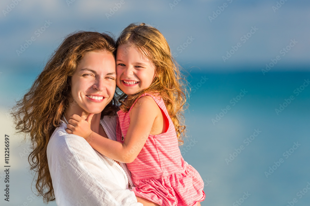 Portrait of mother and little daughter on the beach Portrait of mother and little daughter on the beach