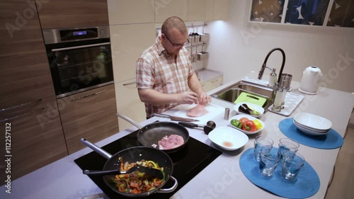 Man Peppers and Fry the Meat  photo