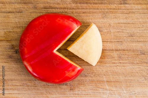 Wheel of fresh gouda cheese with a red rind