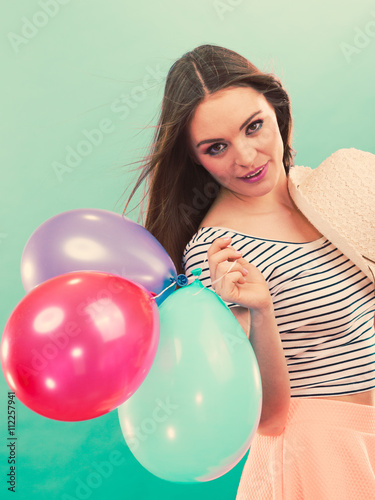 Happy girl playing with colorful balloons.