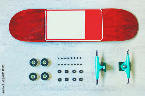 Photos Red skateboard deck with other equipment on the white wood backgroung