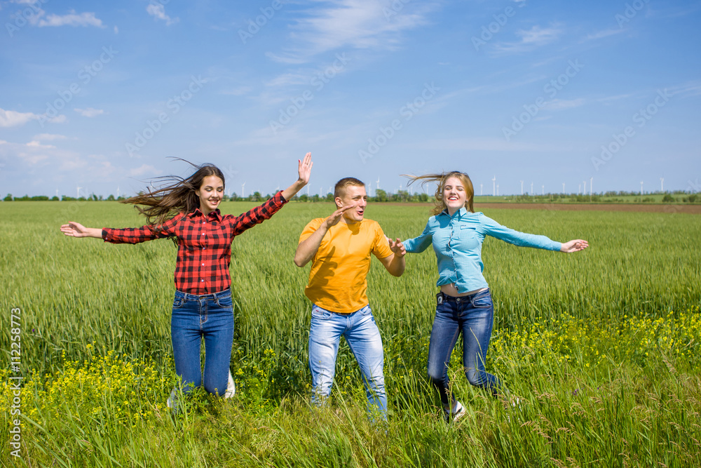 Young happy Friends running on green wheat field Young happy Friends running on green wheat field