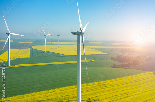 Sunset above the windmills on the field photo