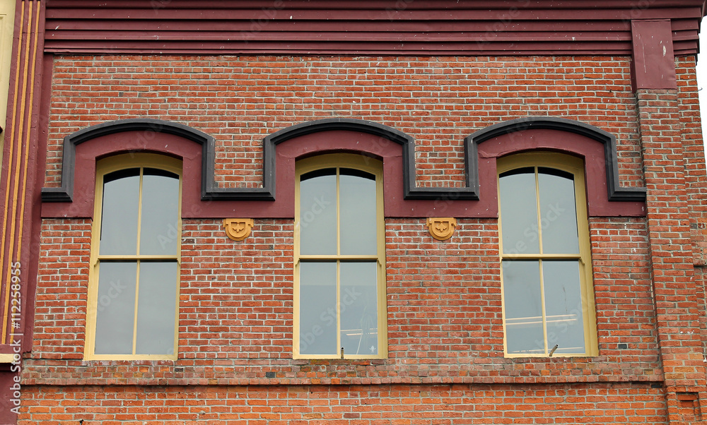 Three Windows in a Red Brick Wall