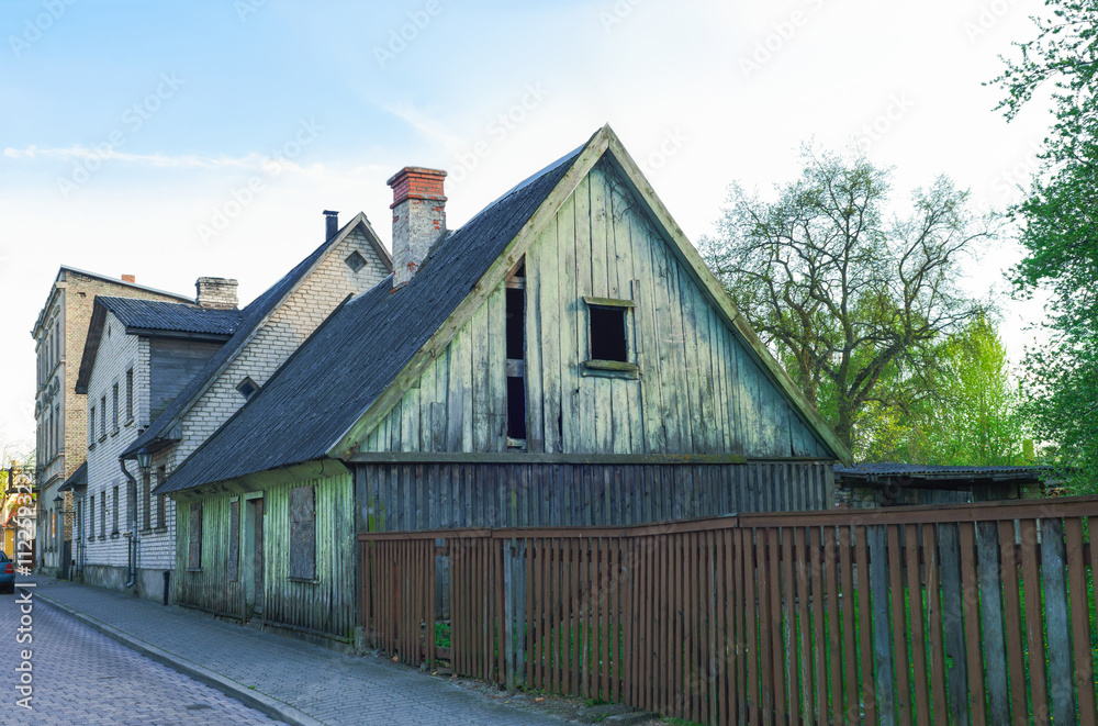 Old wooden house with wooden fence in Ventspils in Latvia Old wooden house with wooden fence in Ventspils in Latvia