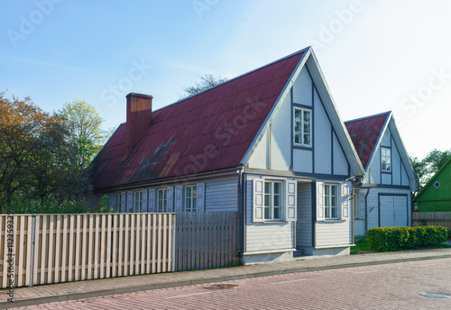 Old wooden house with wooden fence in Ventspils of Latvia