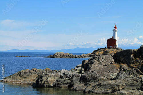 Red and White Lighthouse on a Rocky Coast