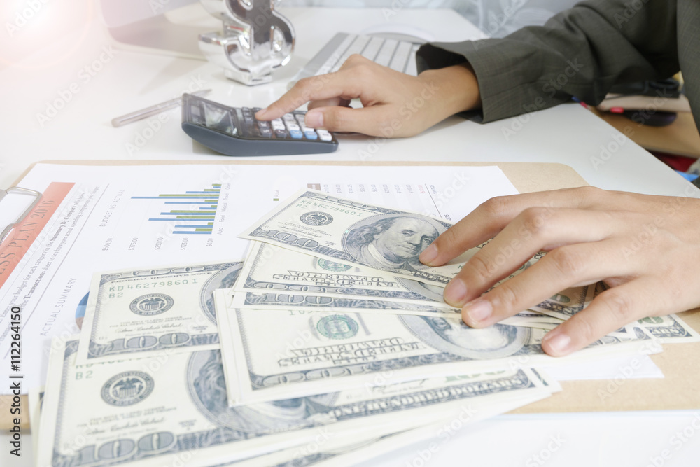 Fototapeta premium business woman hold money dollar with calculator on tablet as fi