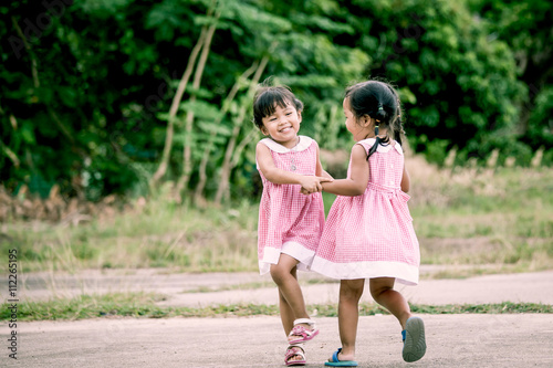 Child two girls having fun to play together in the park © pingpao