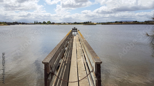 Wooden dock at Shoreline Lake, Mountain View, with a view of Shoreline Amphitheatre, Silicon Valley, California, on a spring morning. photo