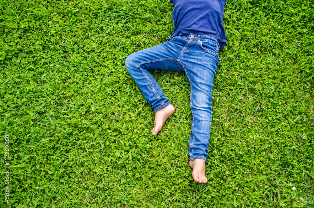 knee up , bare feet baby in blue jeans on the green grass knee up , bare feet baby in blue jeans on the green grass
