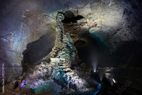Lit lava column at the dark and empty Manjanggul Lava Tube Cave on Jeju Island in South Korea. photo