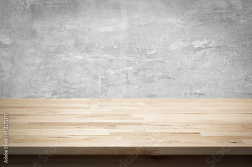 Wood table top on bare concrete wall background