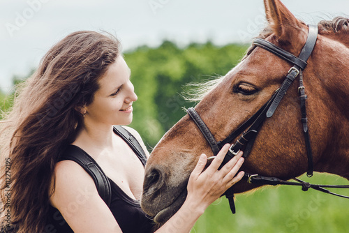 Smiling girl hugs her horse pet