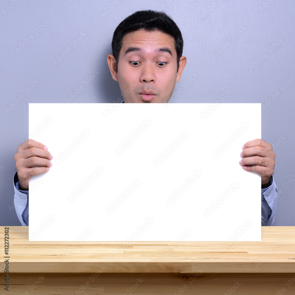 A man with excited face holding and looking at blank white paper A man with excited face holding and looking at blank white paper