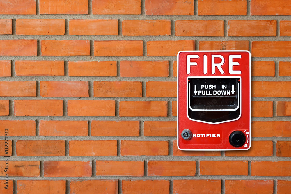 Fototapeta premium Fire alarm switch on brick wall texture background
