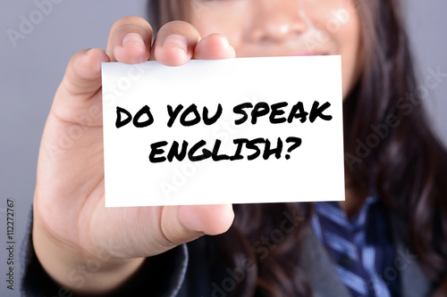 DO YOU SPEAK ENGLISH ? message on the card held by young woman