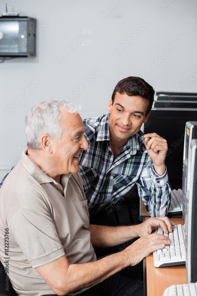 Teacher Assisting Senior Man In Using Computer Lab Teacher Assisting Senior Man In Using Computer Lab