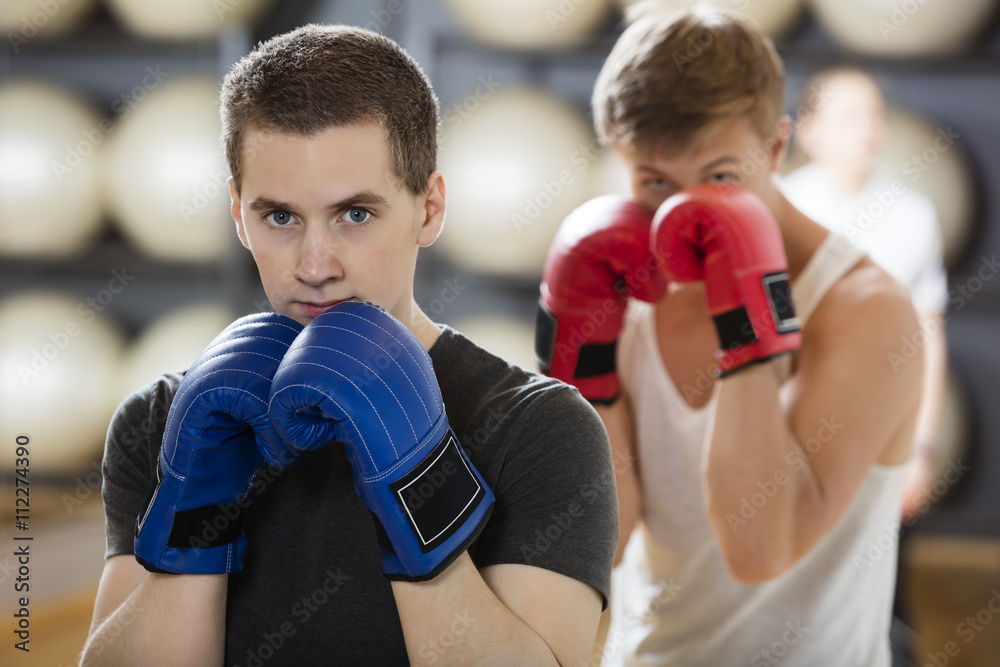 Young Man Wearing Boxing Gloves In Gym