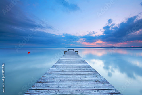 Fototapeta Naklejka Na Ścianę i Meble -  Holzsteg mit Bank am See zum Sonnenuntergang