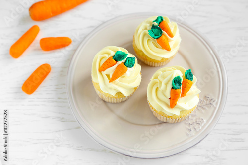 Plate with Easter cupcakes on wooden table photo